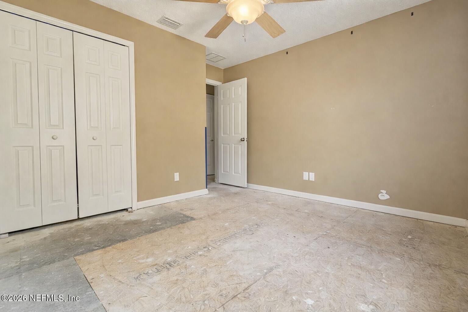 217 Amber Ridge Road Jacksonville, FL 32218 - Photo 19 of 42 an empty room with a ceiling fan and a window