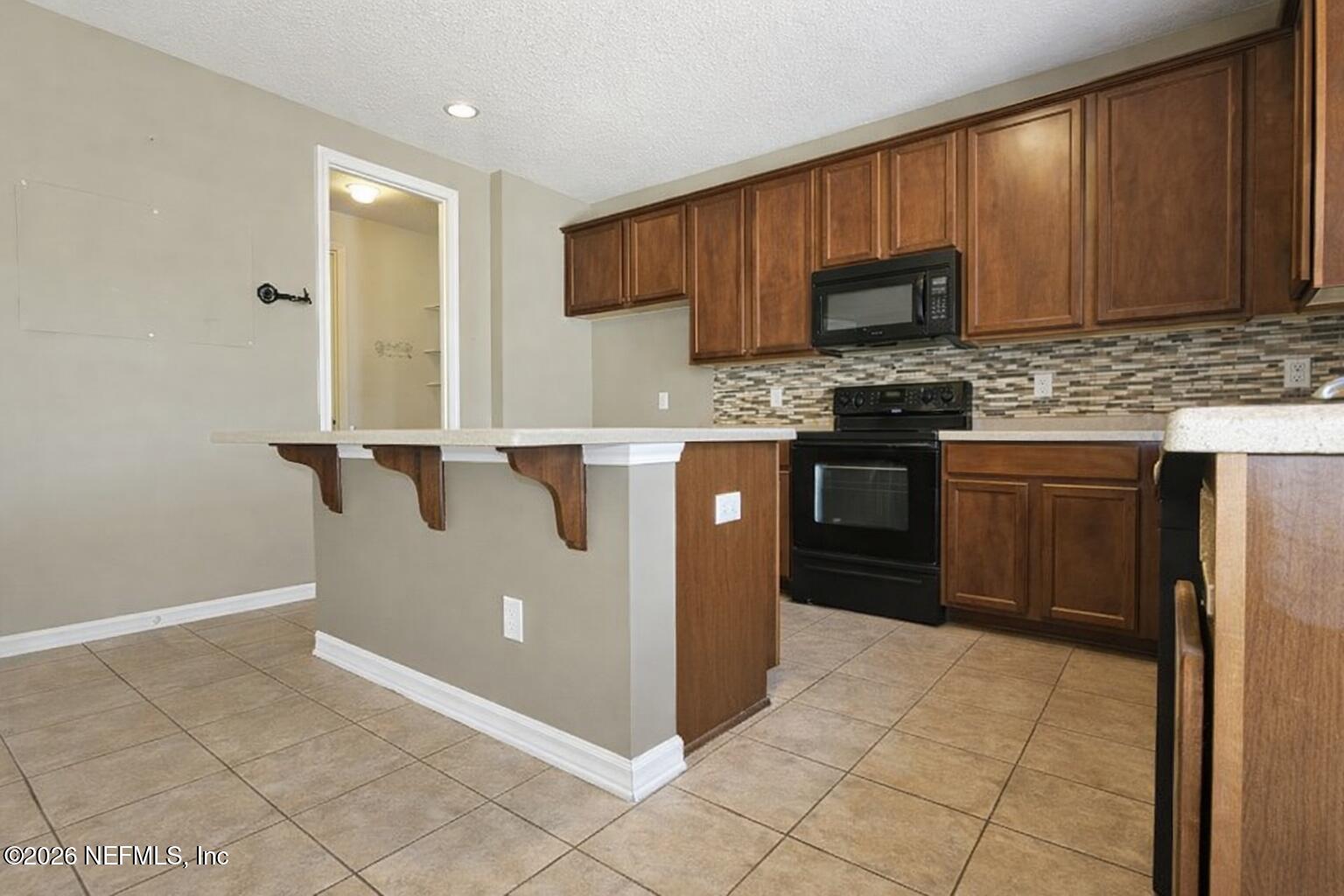 217 Amber Ridge Road Jacksonville, FL 32218 - Photo 21 of 42 a kitchen with stainless steel appliances granite countertop a stove a sink and a microwave