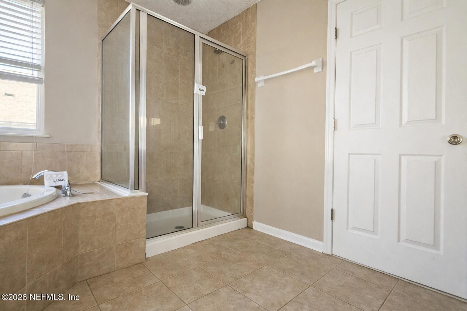 217 Amber Ridge Road Jacksonville, FL 32218 - Photo 22 of 42 a bathroom with a tub and shower