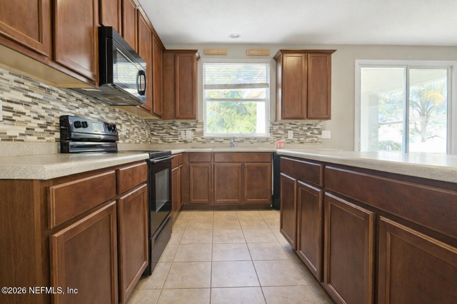 217 Amber Ridge Road Jacksonville, FL 32218 - Photo 29 of 42 a kitchen with stainless steel appliances granite countertop wooden cabinets a sink and a window