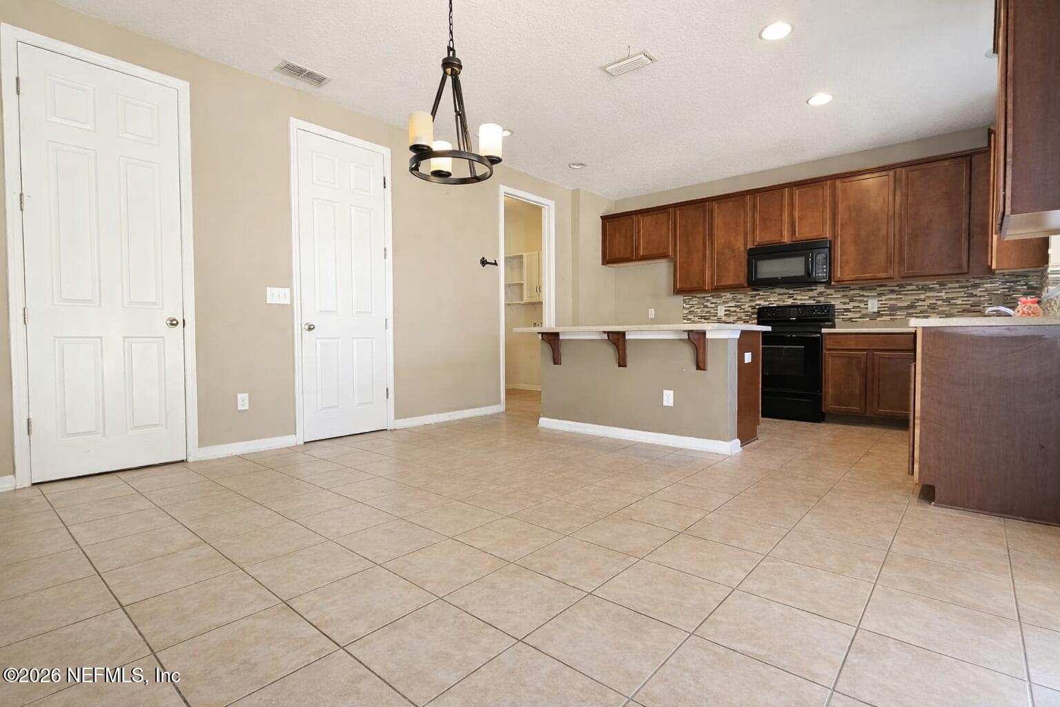 217 Amber Ridge Road Jacksonville, FL 32218 - Photo 5 of 42 a kitchen with kitchen island granite countertop a stove a sink and a refrigerator