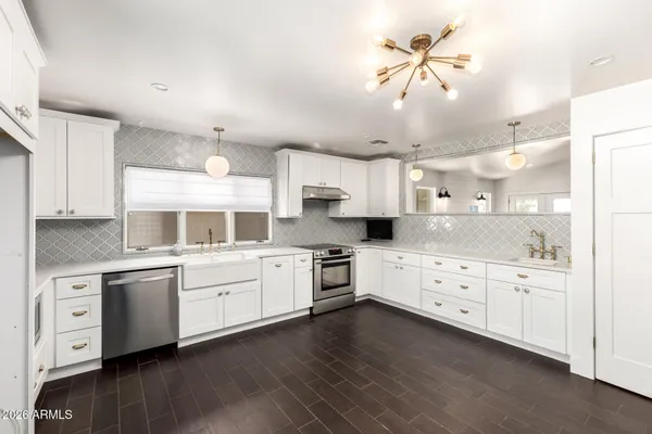 a large kitchen with cabinets wooden floor and stainless steel appliances