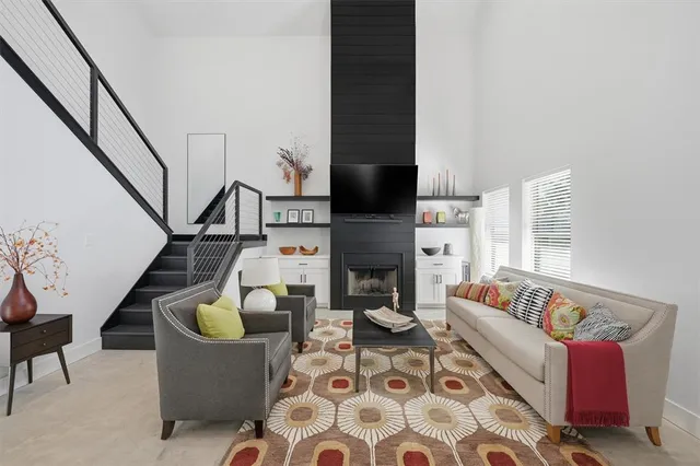 a living room with furniture a flat screen tv and a fireplace
