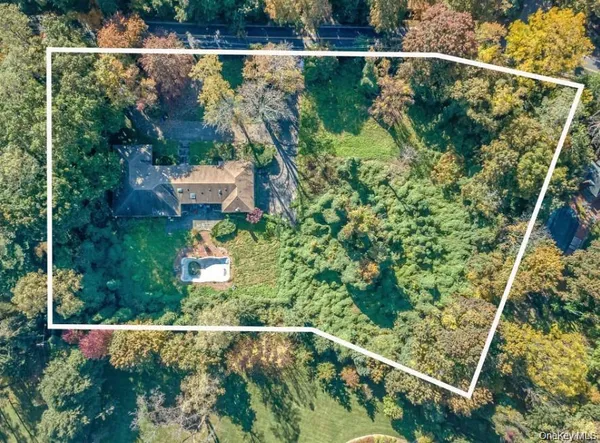 an aerial view of residential house with outdoor space and trees all around