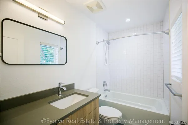a bathroom with a granite countertop sink toilet and shower