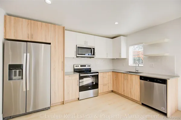 a kitchen with stainless steel appliances a refrigerator sink and microwave