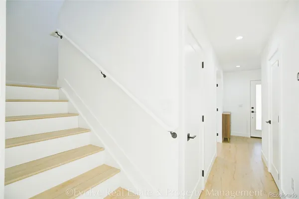 a view of a hallway with white walls and stairs
