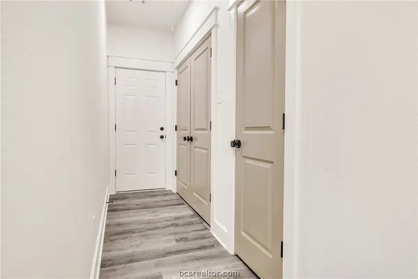 a view of a hallway with wooden floor