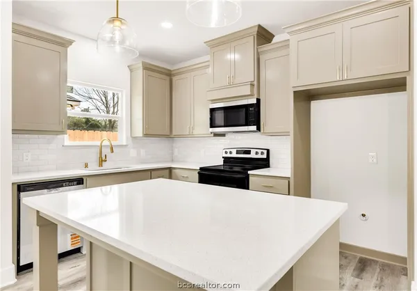 a kitchen with stainless steel appliances a microwave a sink a stove and refrigerator