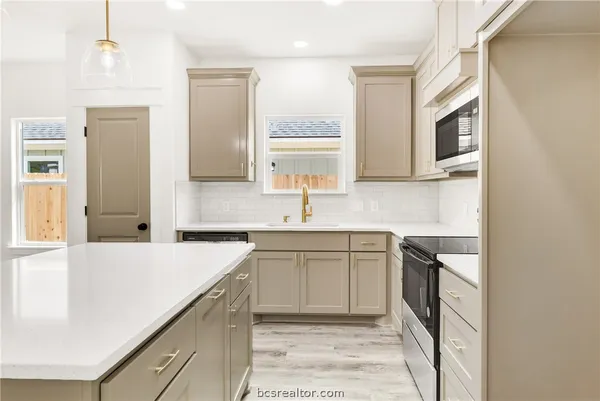 a kitchen with a sink and a stove top oven