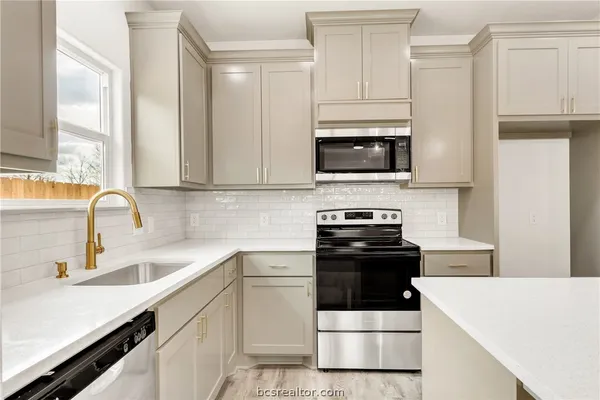 a kitchen with granite countertop white cabinets and white appliances