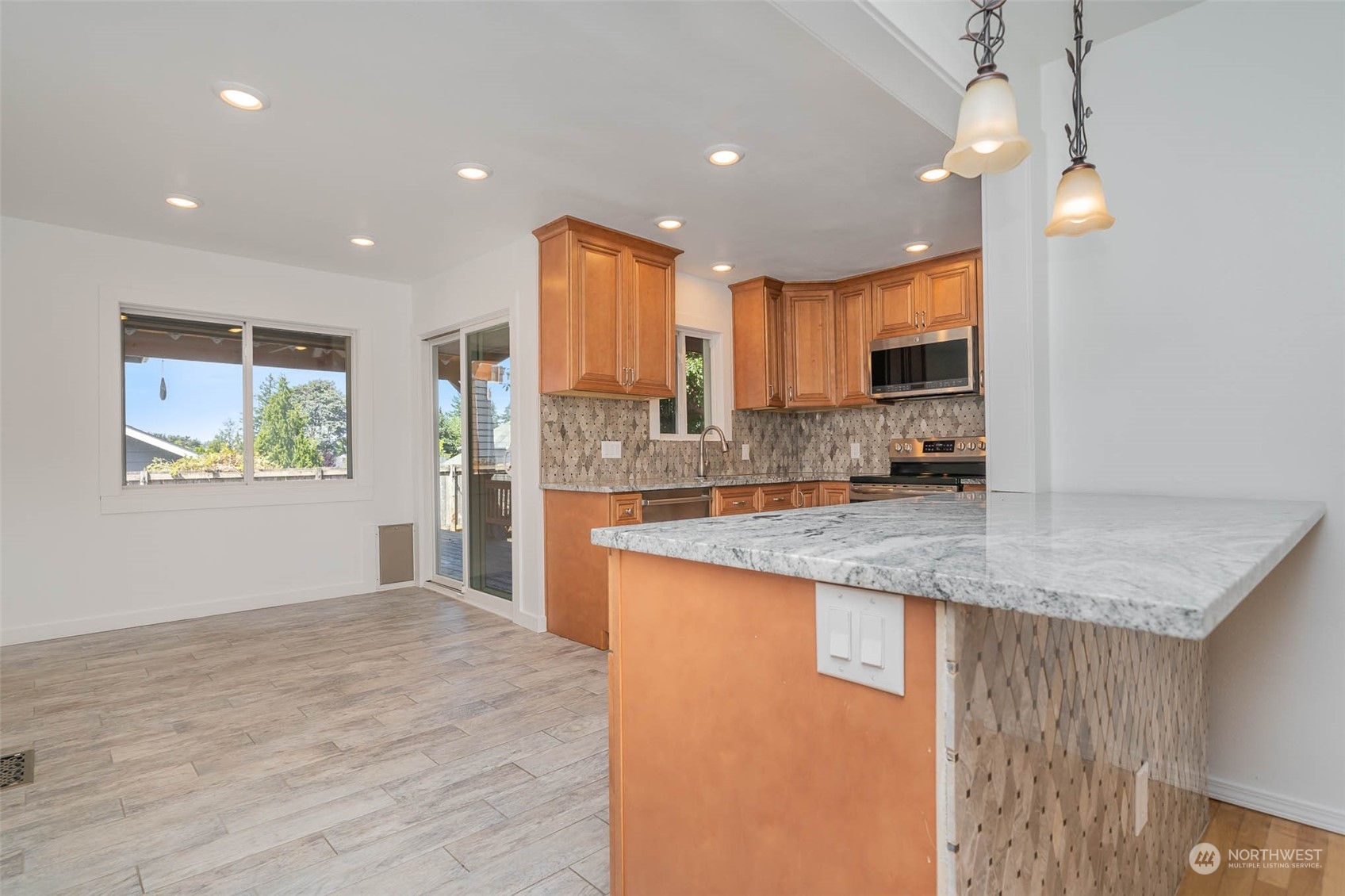 1709 Edmonds Avenue Northeast Renton, WA 98056 - Photo 5 of 31 a kitchen with stainless steel appliances granite countertop a sink refrigerator and cabinets