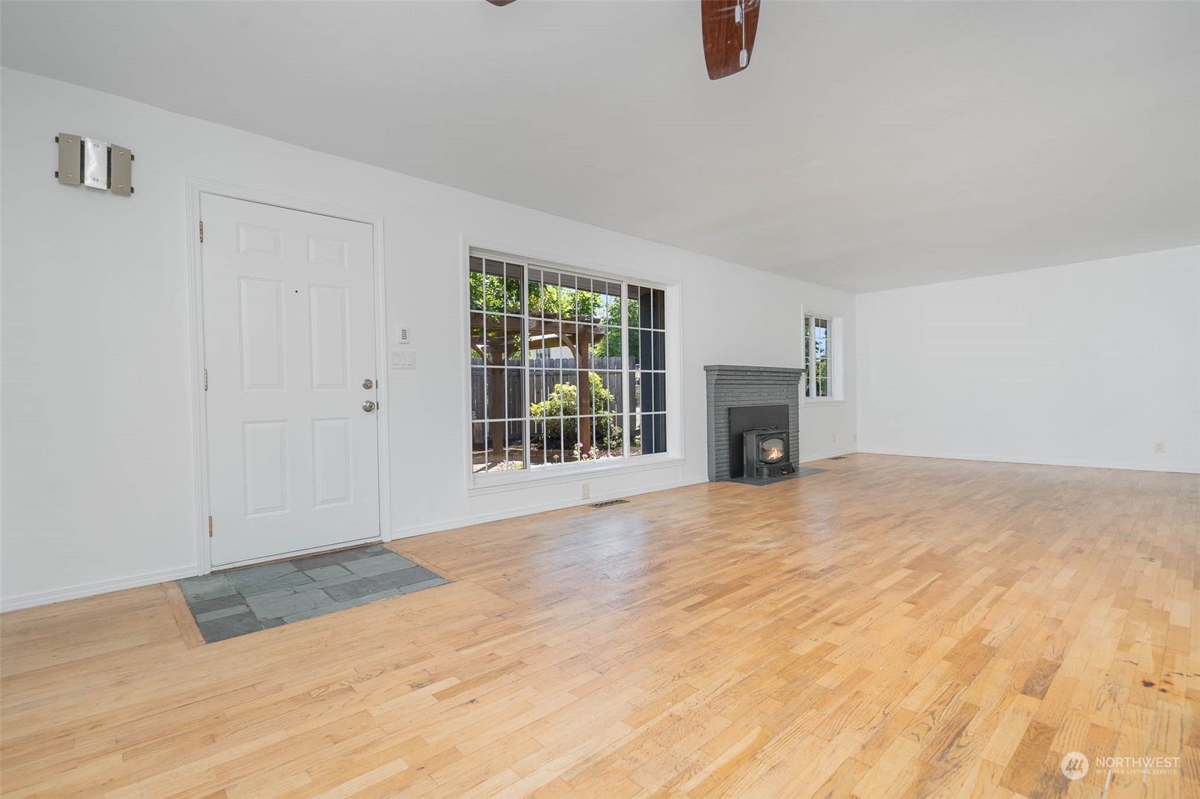 1709 Edmonds Avenue Northeast Renton, WA 98056 - Photo 9 of 31 a view of an empty room with wooden floor fireplace and windows