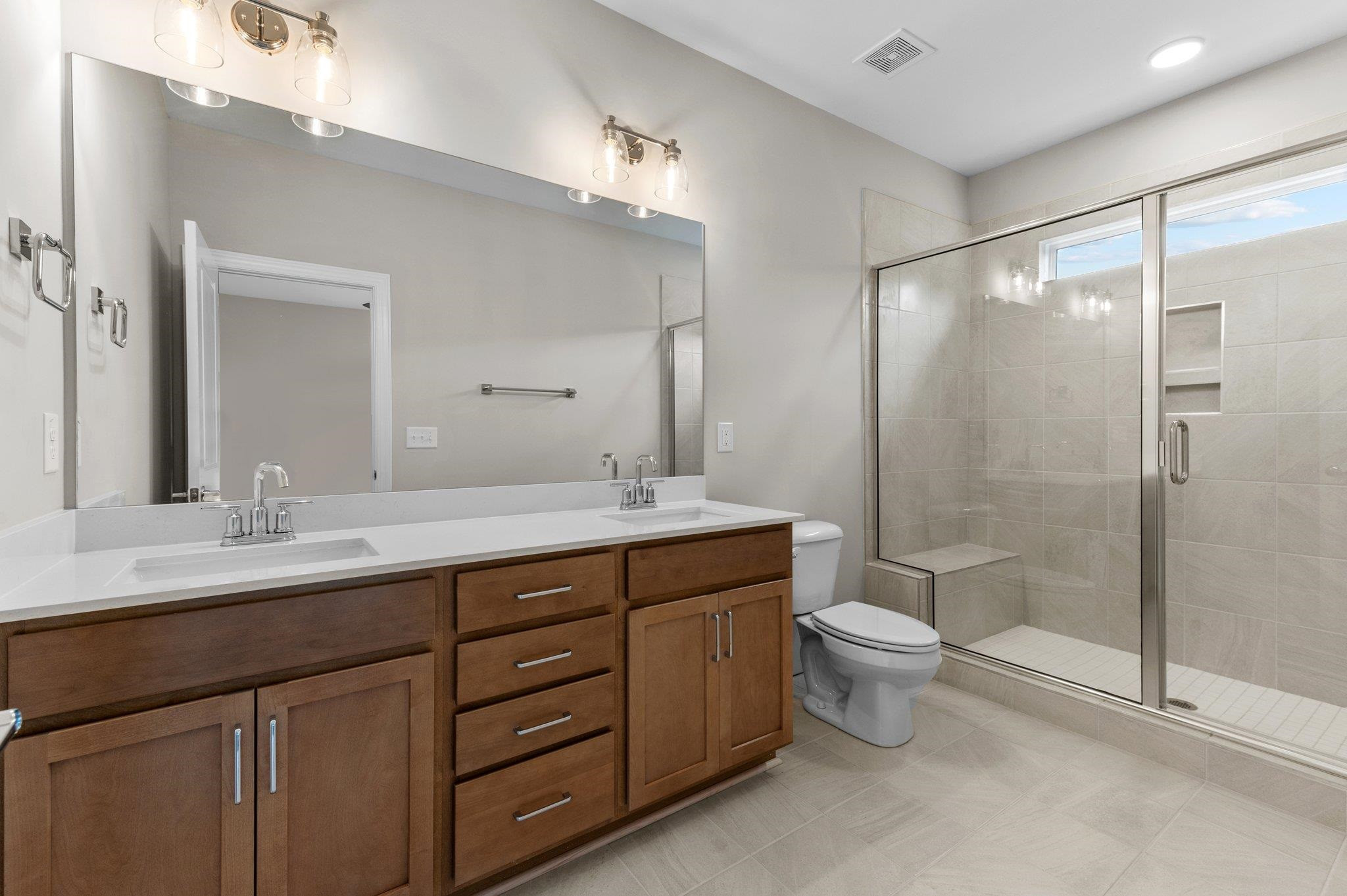 609 Marshskip Way, Unit 5 Rolesville, NC 27571 - Photo 12 of 39 a bathroom with a double vanity sink toilet mirror and shower