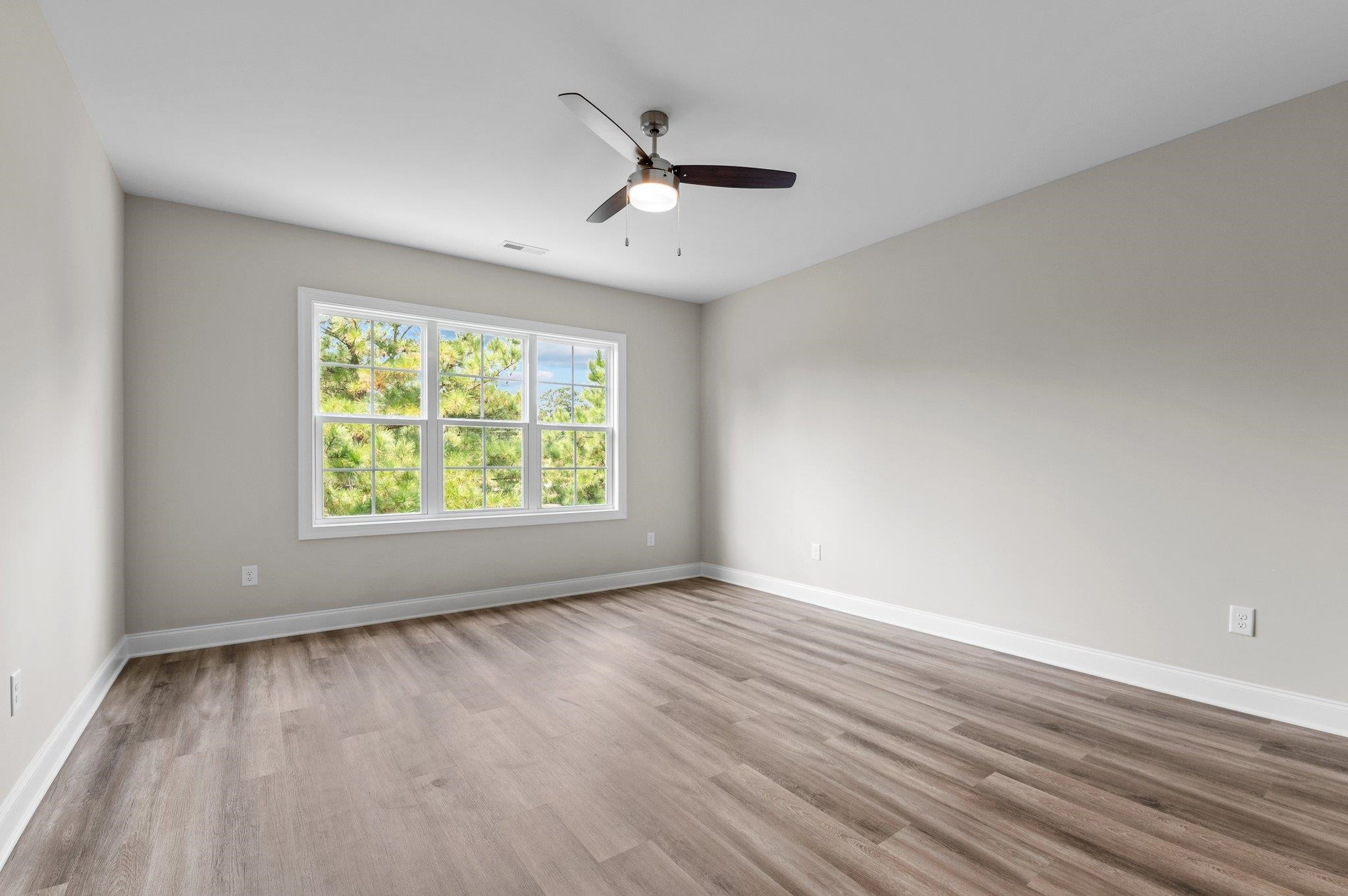 609 Marshskip Way, Unit 5 Rolesville, NC 27571 - Photo 16 of 39 an empty room with wooden floor chandelier fan and windows