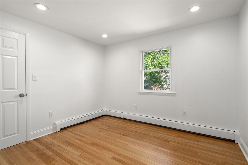 13 Doane Road Medford, MA 02155 - Photo 20 of 42 a view of an empty room with wooden floor and a window