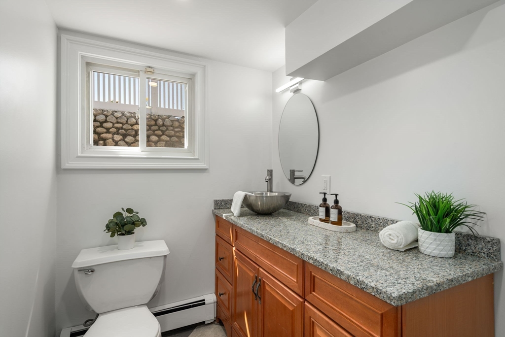13 Doane Road Medford, MA 02155 - Photo 35 of 42 a bathroom with a granite countertop sink a toilet and a mirror