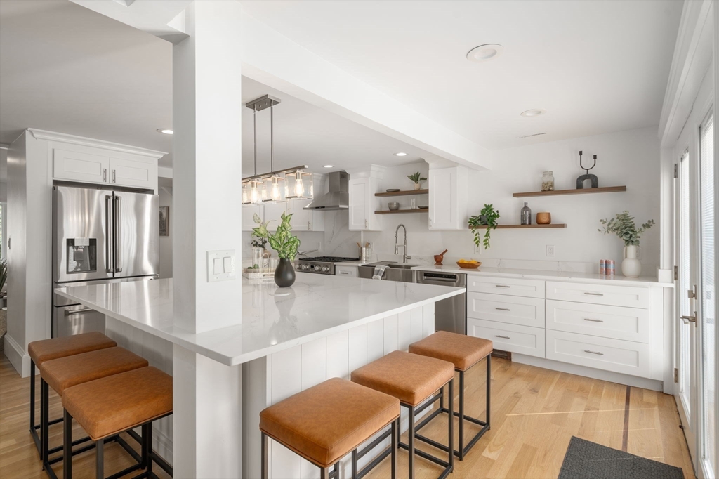 13 Doane Road Medford, MA 02155 - Photo 4 of 42 a kitchen with white cabinets and chairs