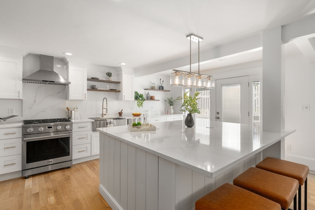 13 Doane Road Medford, MA 02155 - Photo 5 of 42 a kitchen with kitchen island a stove a chimney a sink and cabinets