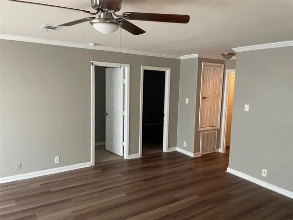 a view of an empty room with wooden floor