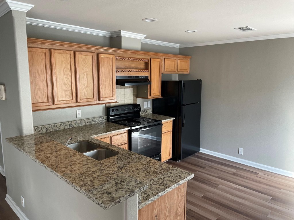 8715 Knox Street, Unit A Houston, TX 77088 - Photo 4 of 11 a kitchen with stainless steel appliances granite countertop a sink stove and refrigerator