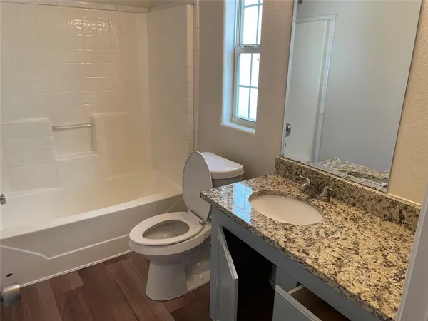 a bathroom with a granite countertop sink a toilet and a bathtub