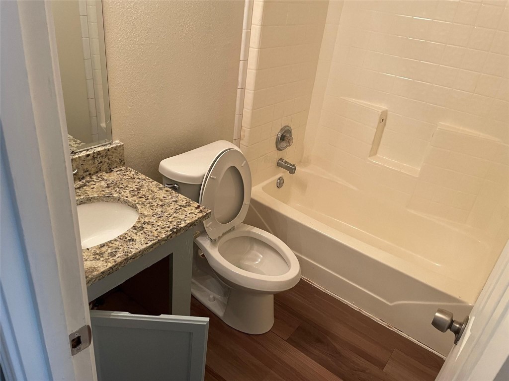 8715 Knox Street, Unit A Houston, TX 77088 - Photo 9 of 11 a bathroom with a granite countertop toilet sink and mirror