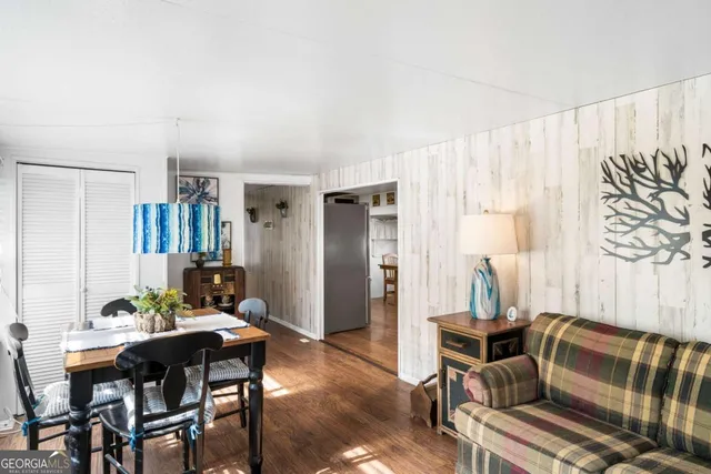 a living room with furniture kitchen view and a large window