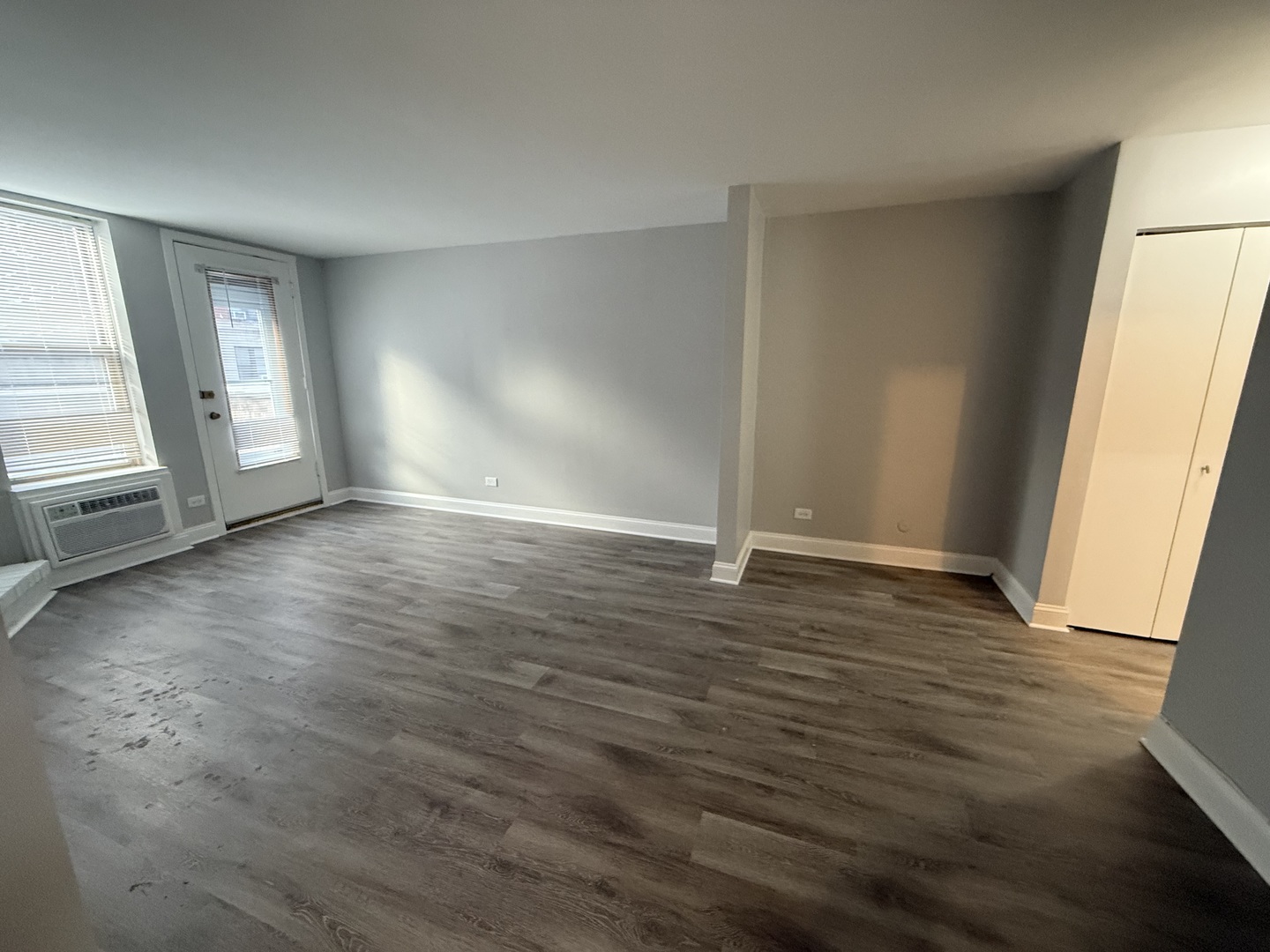 744 West Gordon Terrace, Unit 101 Chicago, IL 60613 - Photo 3 of 10 an empty room with wooden floor and windows