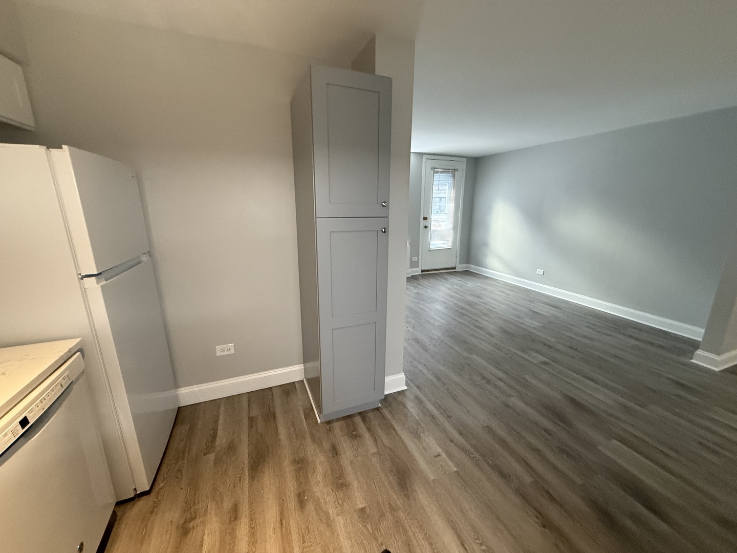 744 West Gordon Terrace, Unit 101 Chicago, IL 60613 - Photo 4 of 10 an empty room with wooden floor and entrance