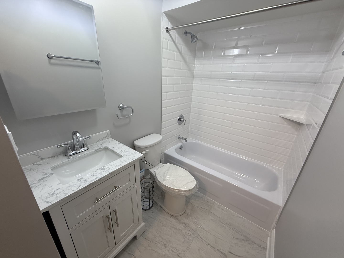 744 West Gordon Terrace, Unit 101 Chicago, IL 60613 - Photo 9 of 10 a bathroom with a granite countertop sink toilet and shower