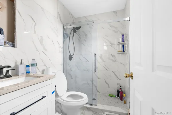 a bathroom with a sink a toilet and shower