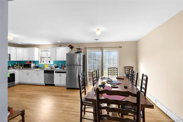 a kitchen with stainless steel appliances wooden floor and dining table