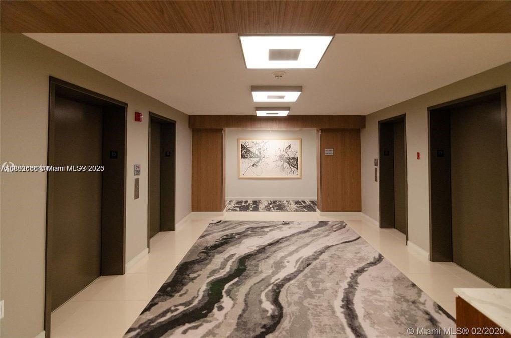 2889 McFarlane Road, Unit 909 Miami, FL 33133 - Photo 21 of 36 a bedroom with a bed and a large mirror