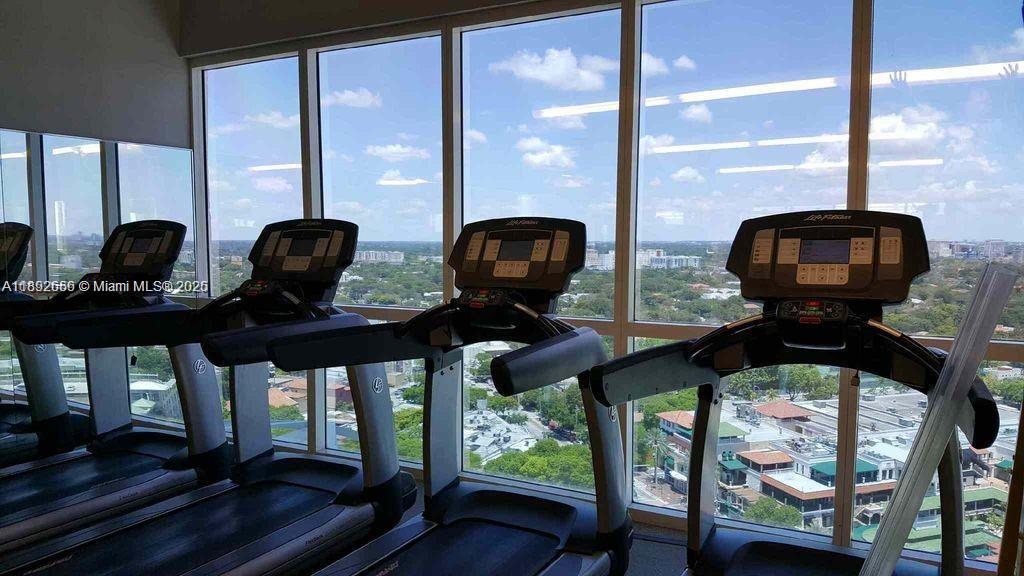 2889 McFarlane Road, Unit 909 Miami, FL 33133 - Photo 26 of 36 a view of living room with furniture and floor to ceiling windows