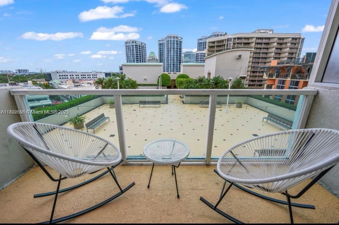 2889 McFarlane Road, Unit 909 Miami, FL 33133 - Photo 31 of 36 a view of a chairs and table in the balcony