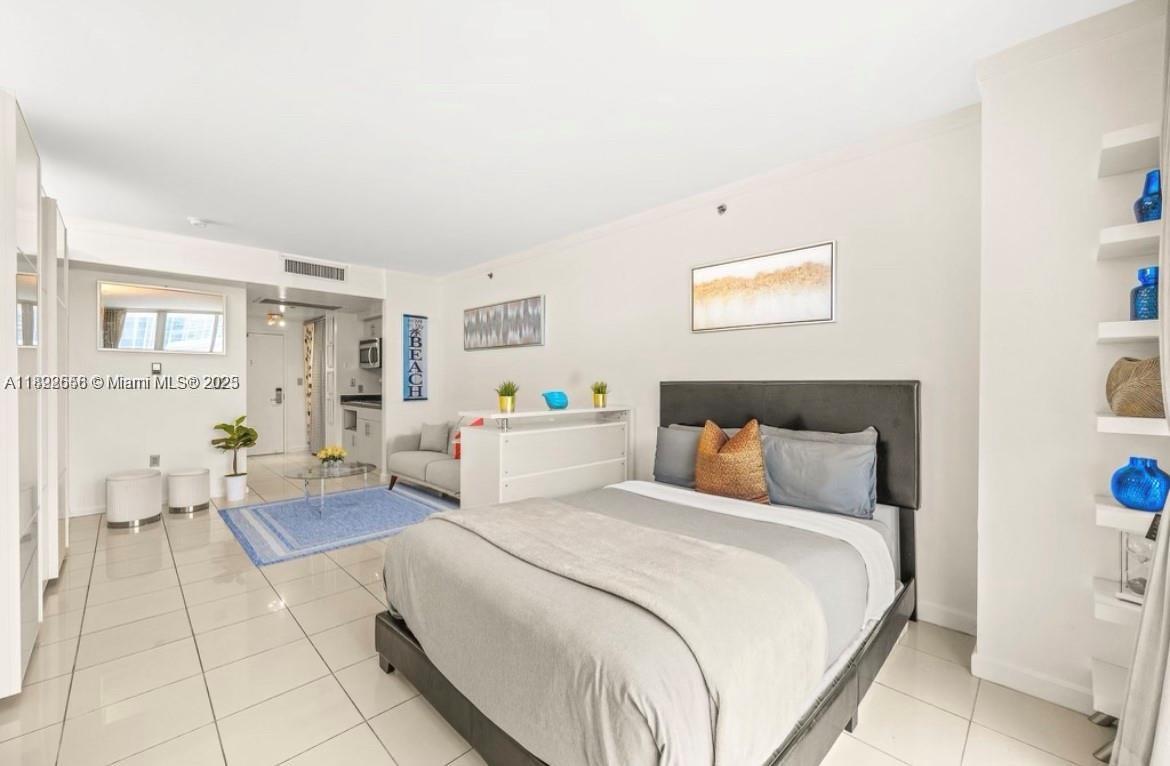 2889 McFarlane Road, Unit 909 Miami, FL 33133 - Photo 33 of 36 a bedroom with a bed and a couch