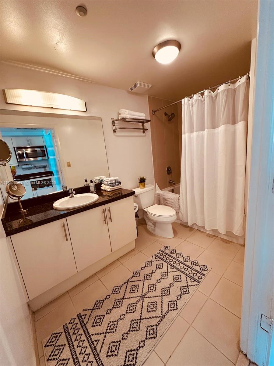 2889 McFarlane Road, Unit 909 Miami, FL 33133 - Photo 6 of 36 a bathroom with a sink toilet and shower