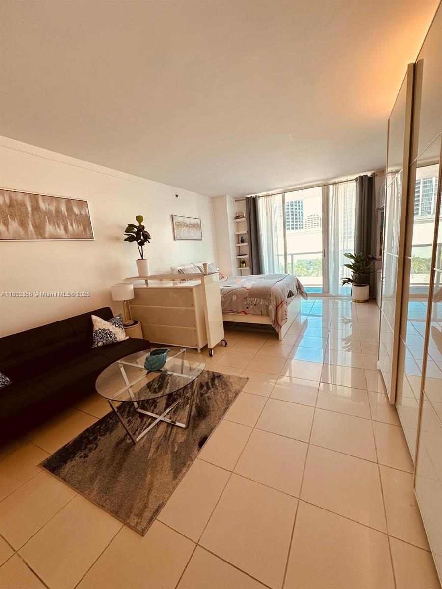 2889 McFarlane Road, Unit 909 Miami, FL 33133 - Photo 9 of 36 a living room with furniture and a large window