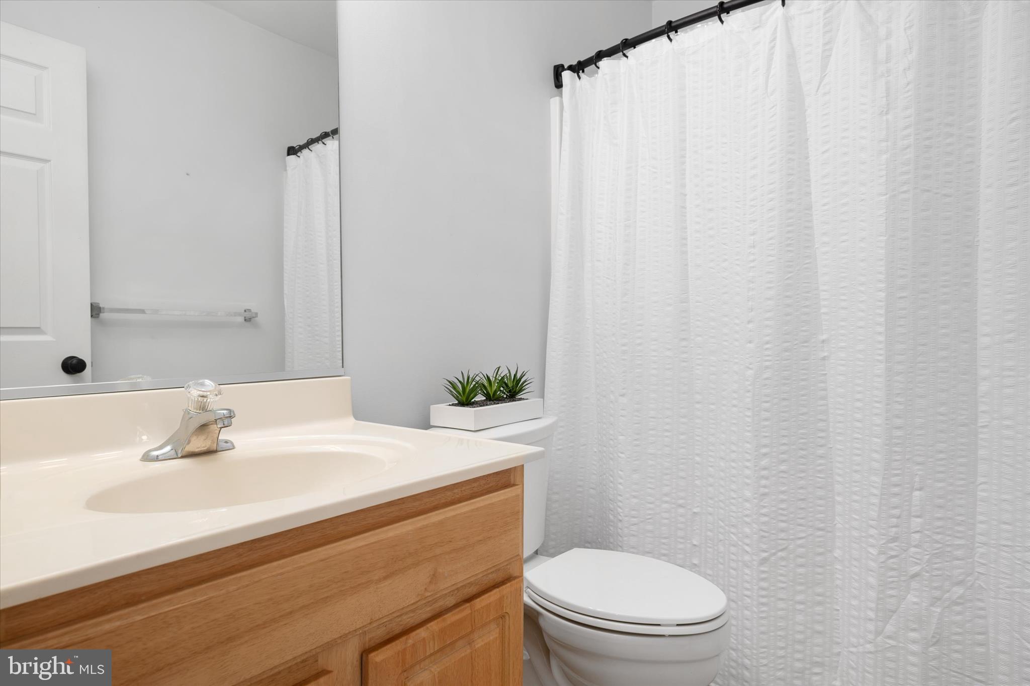 913 Clark Corner Road Centreville, MD 21617 - Photo 33 of 66 a bathroom with a sink a toilet and shower curtain