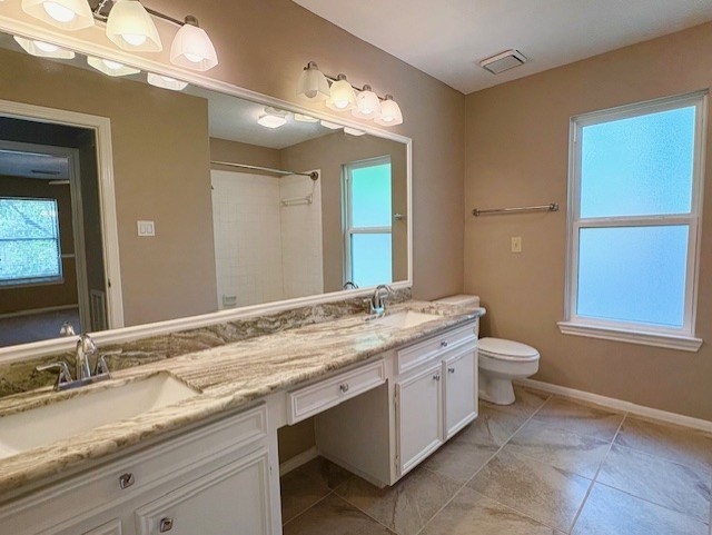 17706 Woodlode Lane Spring, TX 77379 - Photo 25 of 31 a bathroom with a granite countertop sink a toilet and a mirror
