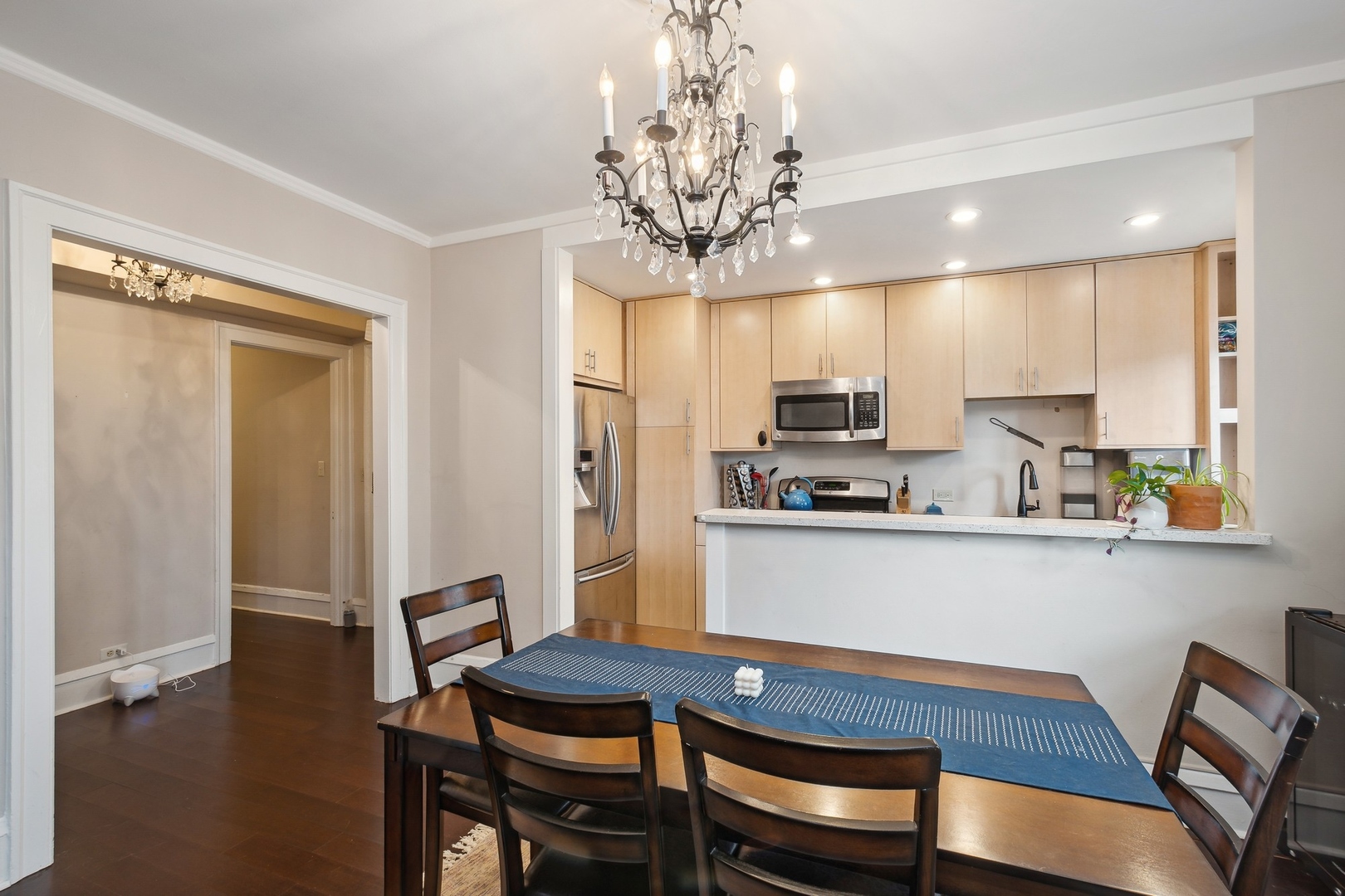 400 West Deming Place, Unit 2K Chicago, IL 60614 - Photo 7 of 10 a kitchen with stainless steel appliances granite countertop a dining table chairs and chandelier