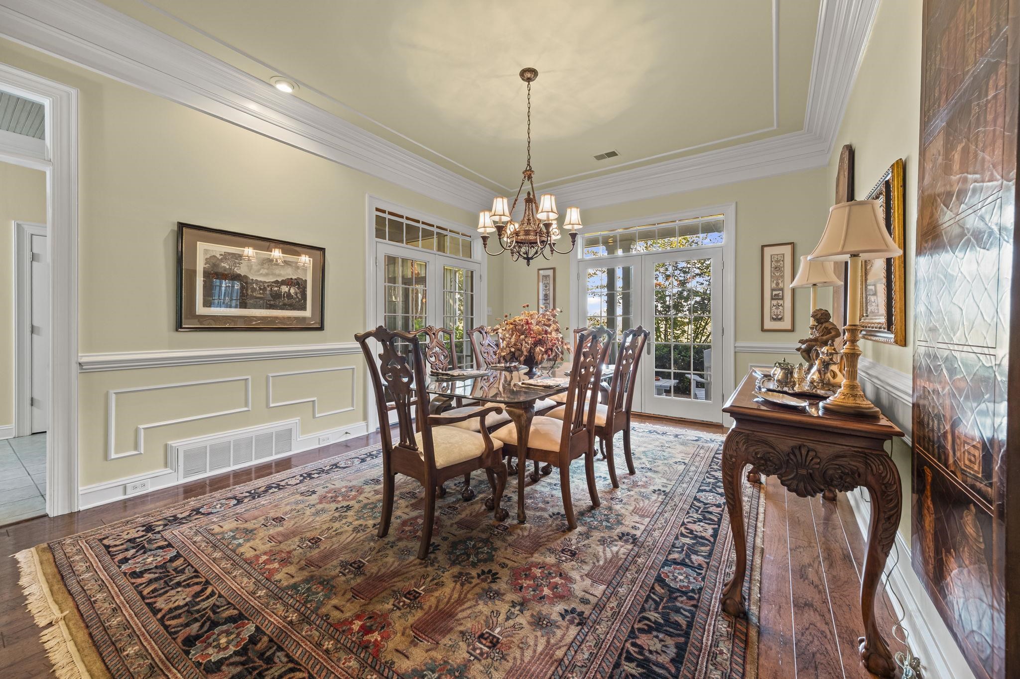450 Cherry Road Eads, TN 38028 - Photo 9 of 24 Dining room with crown molding, a decorative wall, wainscoting, dark wood-type flooring, and a chandelier