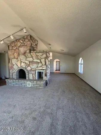 an empty room with a window and ceiling fan