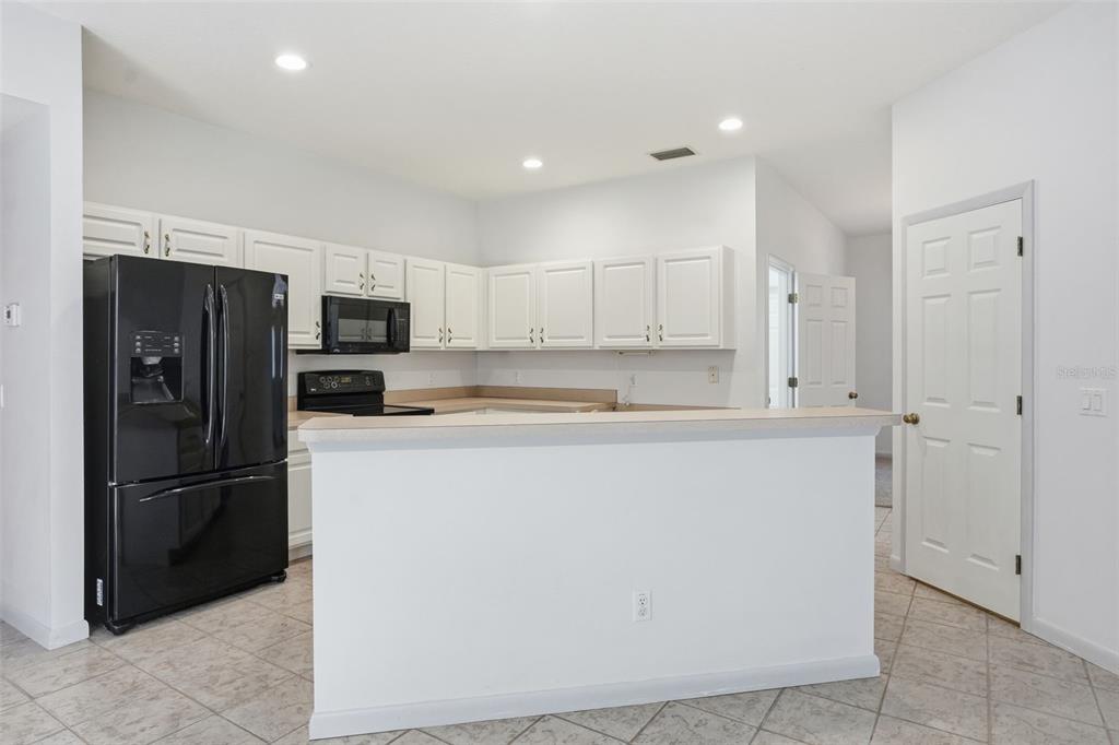 16 Nephthytis Court Homosassa, FL 34446 - Photo 14 of 45 a kitchen with a refrigerator a microwave and sink