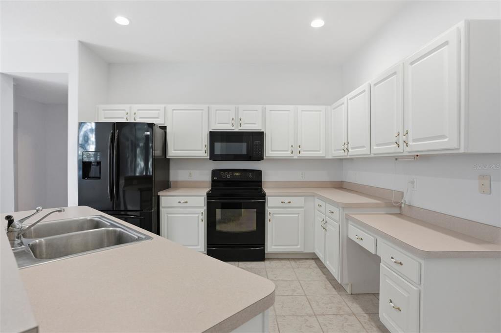 16 Nephthytis Court Homosassa, FL 34446 - Photo 15 of 45 a kitchen with white cabinets and stainless steel appliances
