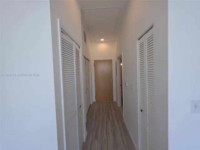 a view of a hallway with wooden floor