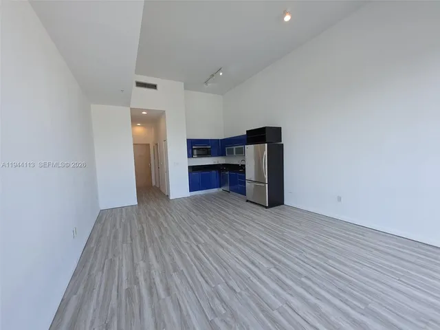 a view of empty room with a fireplace and wooden floor