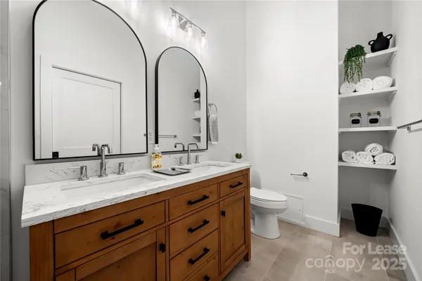 a bathroom with a double vanity sink mirror and shower