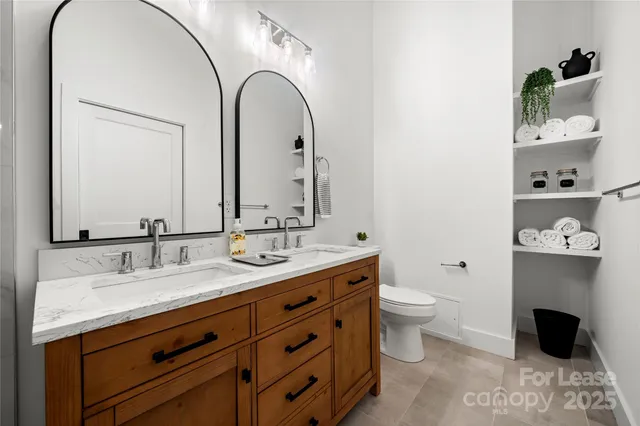 a bathroom with a double vanity sink mirror and shower